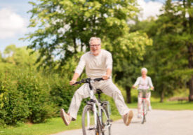 Active Lifestyle with Elder Couples Riding a Bicycle Outdoors