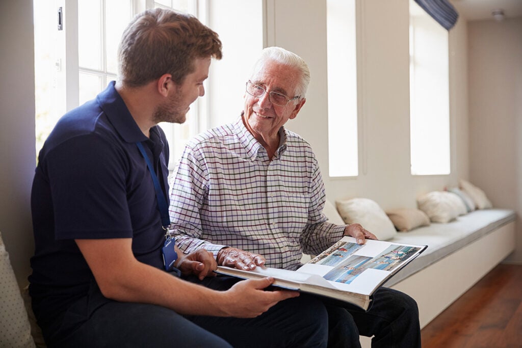Male Nurse sitting with elder for memory care