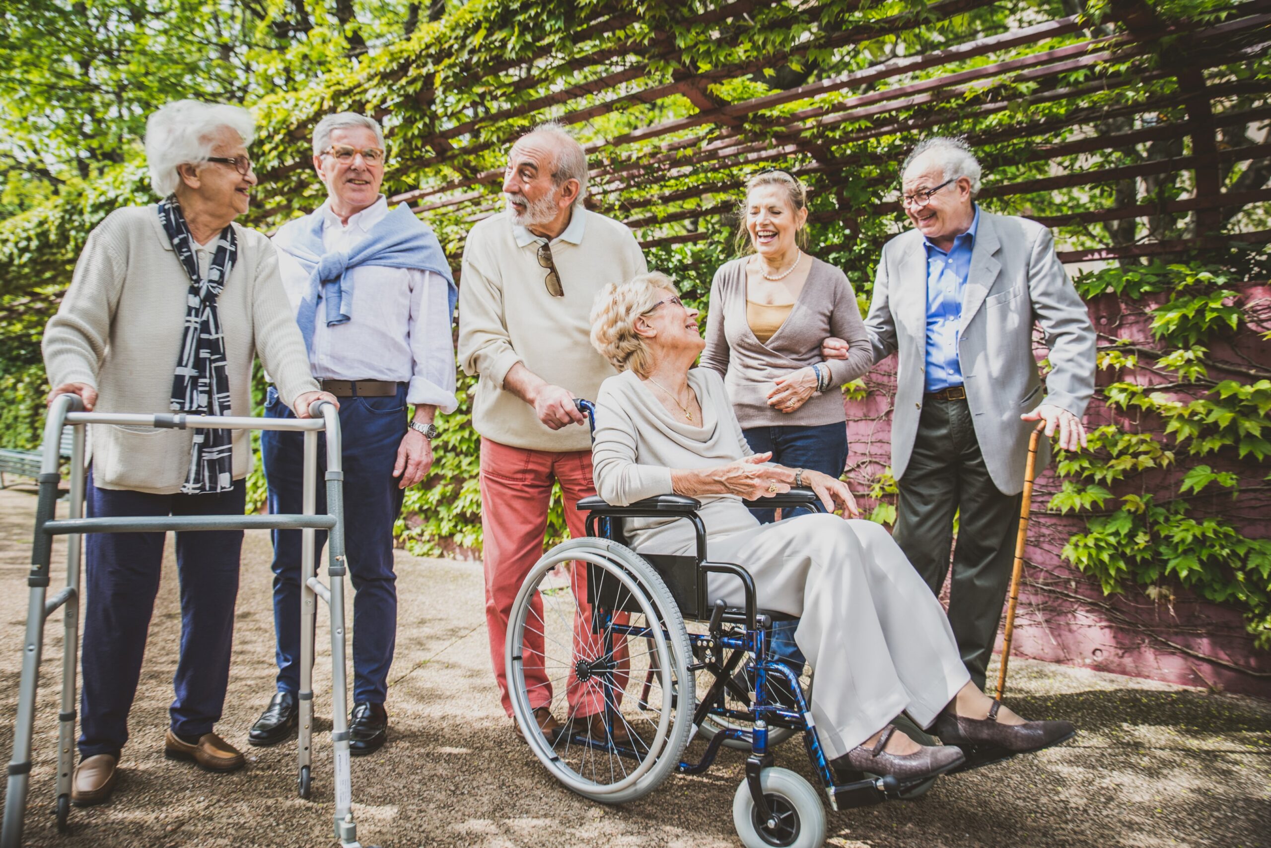 Elderly people in a garden setting, wheelchair and a walker
