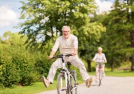 Active Lifestyle with Elder Couples Riding a Bicycle Outdoors
