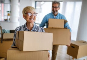 Happy Elder Couple moving and downsizing on bright sunny day