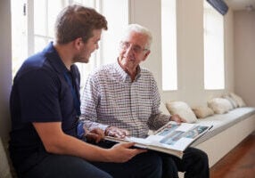 Male Nurse sitting with elder for memory care