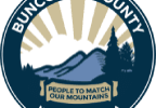 Circular logo for Buncombe County, North Carolina, featuring stylized mountains, trees, and a sunrise. Text reads Buncombe County at the top and North Carolina at the bottom, with People to Match Our Mountains on a ribbon. The design reflects the vibrant spirit of Asheville and its scenic beauty.